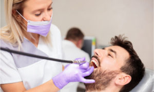 The dentist cleans the patient's mouth before proceeding to the dental treatment.